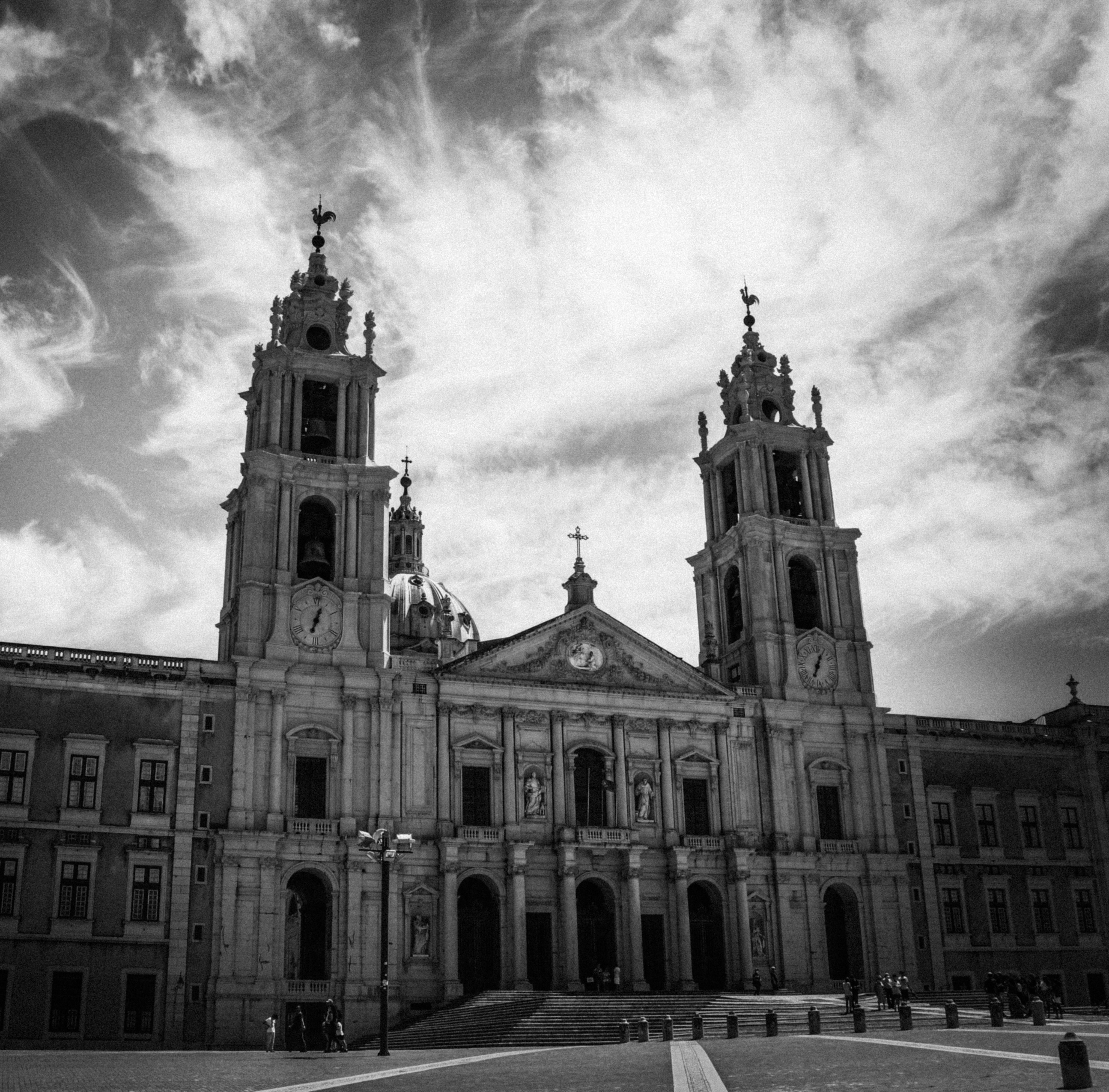 The Palace of Mafra in black and white, its baroque towers rising against a dramatic sky