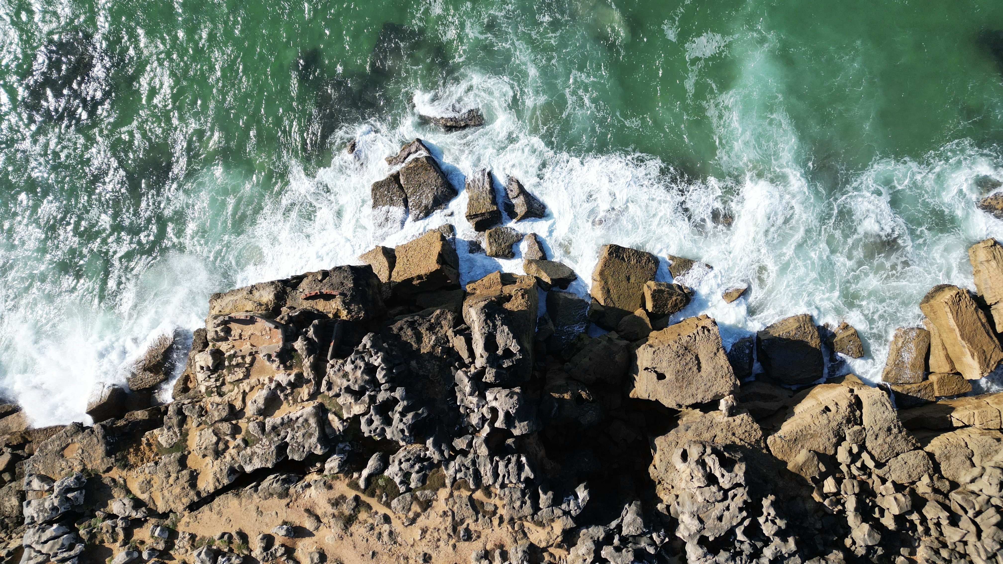 Aerial view of Atlantic waves crashing against the rocky Portuguese coastline