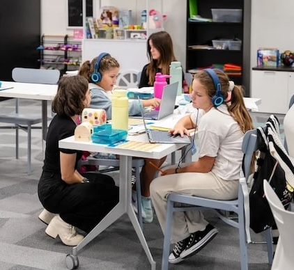 Students working alongside each other in a bright, naturally lit room